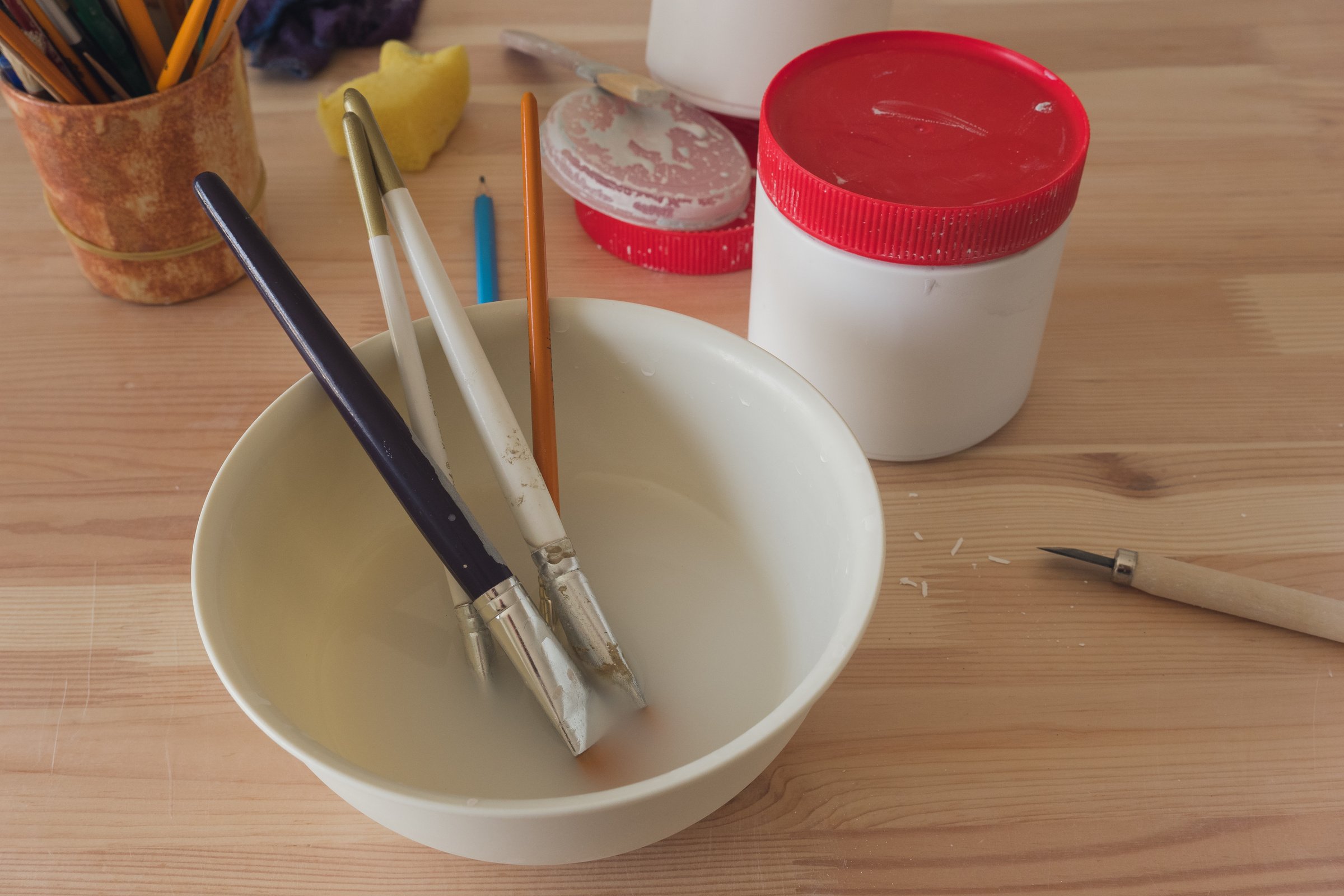 Ceramic glaze and paint brushes.