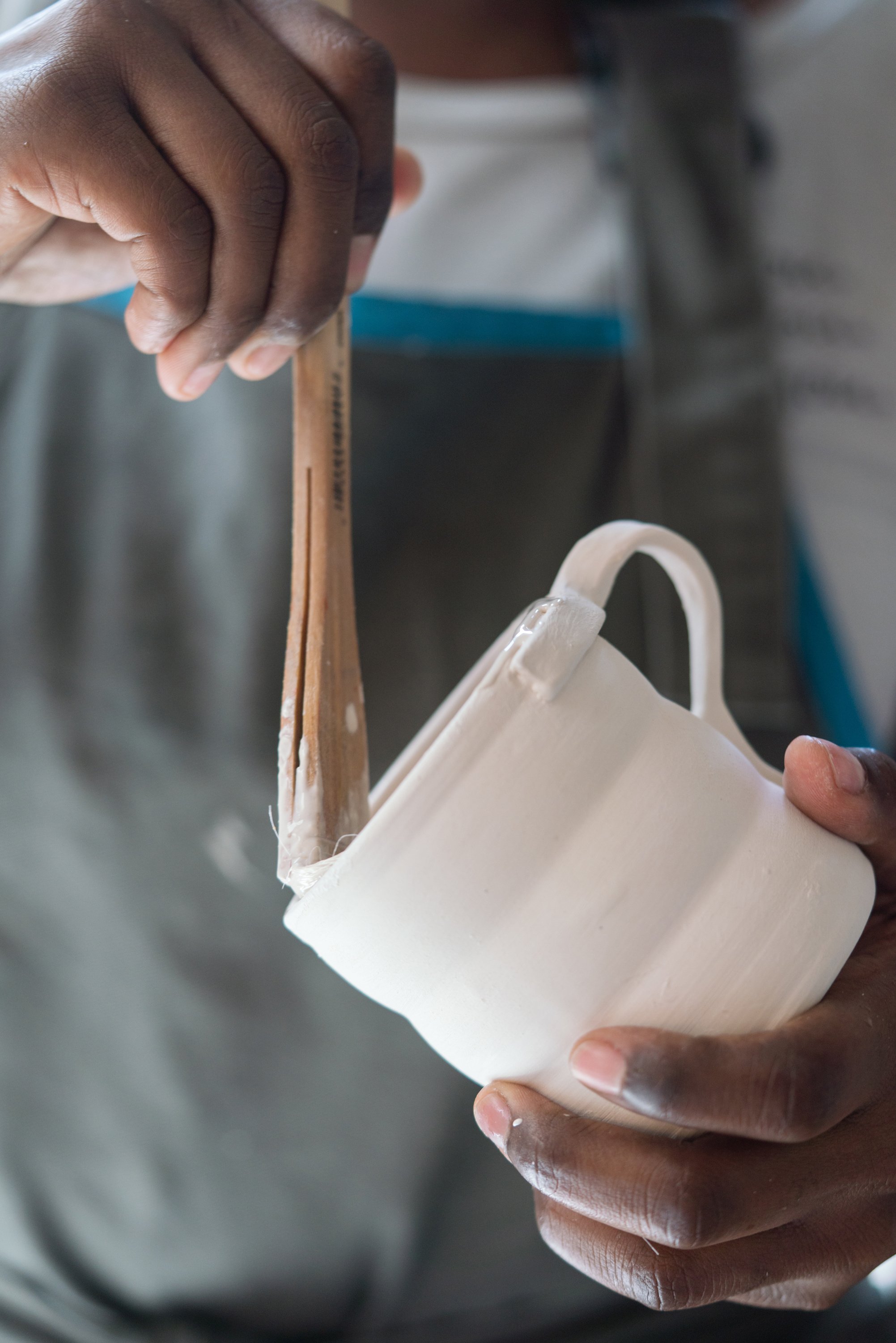 Female ceramic artist glazing a cup