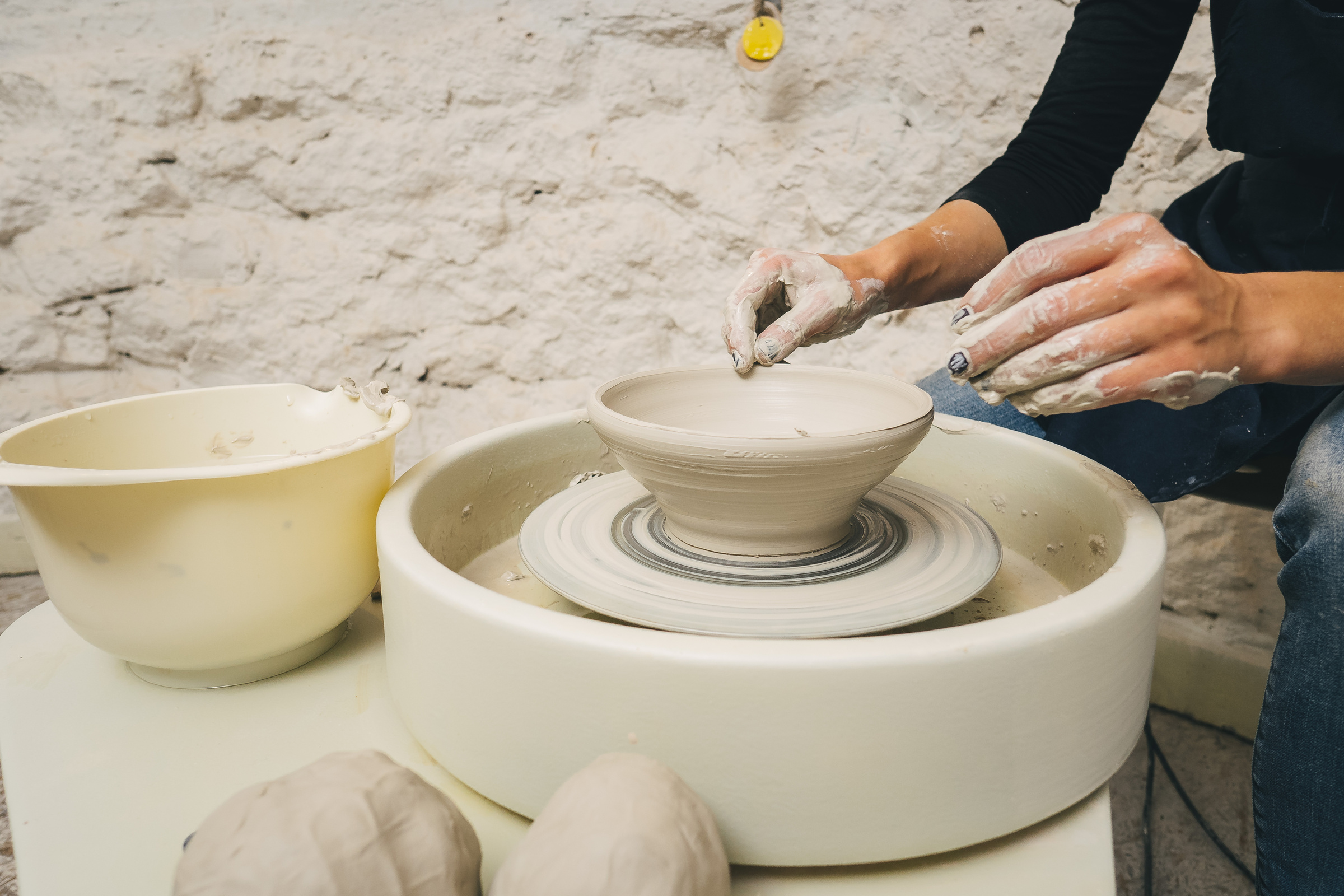 Hands working on pottery wheel