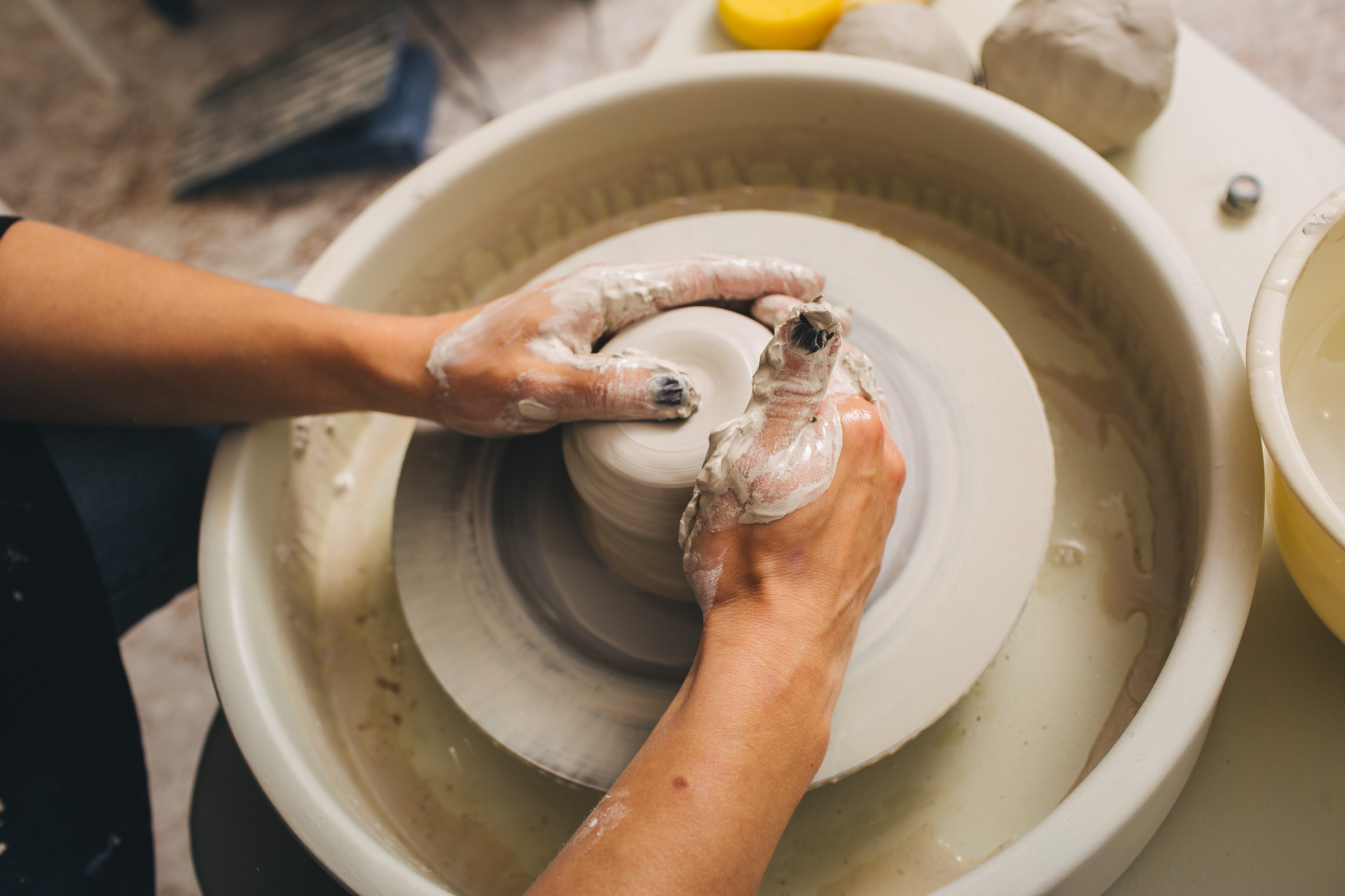 Hands working on pottery wheel