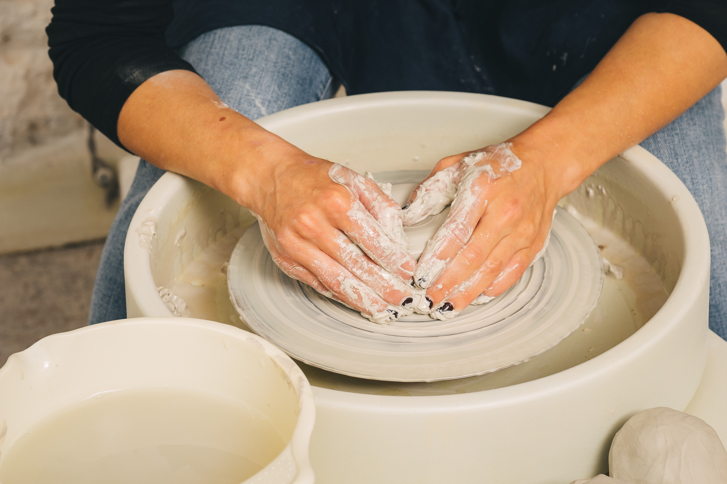 Hands working on pottery wheel